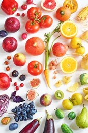rainbow colored fruits and vegetables on a white table. juice and smoothie ingredients. healthy eating / diet concept.