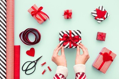 female hands tying a red bow. birthday, valentines day, christmas, new year. flat lay