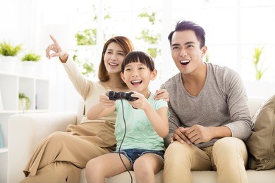 laughing family playing video games in living room