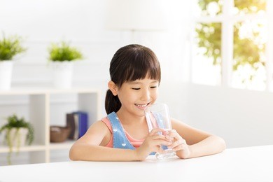 happy child drinking water from glass