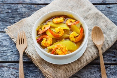 hot and sour curry with tamarind sauce of papaya and shrimp .spicy food thai food .herb and healthy food on wooden table.