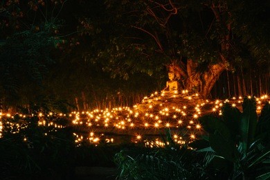 candle light with buddha statue at wat pan tao temple, chiangmai, thailand.vintage retro concept with film grain