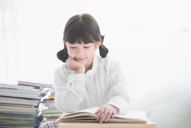beautiful asian girl reading a book under sunlight