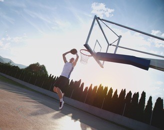 young man jumping and making a fantastic slam dunk playing streetball, basketball. urban authentic.