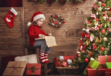 merry christmas! cute little child girl writes the letter to santa claus.