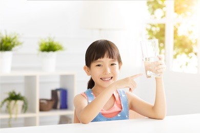happy child drinking water from glass