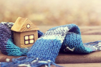 small wooden house in a warm blue scarf / property insurance