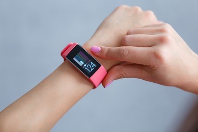 isolated female hand with pink smartwatch taking pulse after exercising
