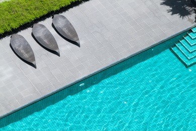 a top view of rooftop swimming pool with beds