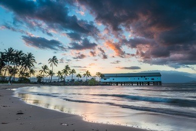 sun sets over the port douglas pier on another glorious day in queensland.