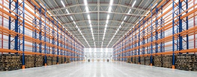 panorama of an empty huge distribution warehouse with high shelves and pallet
