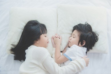 top view of cute asian children sleeping and holding hand together