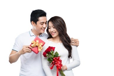 asian man makes present to his lovely sweetheart. young man giving a gift. cheerful young couple man and woman at home offering to each other gifts for lover's valentine day