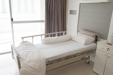 bedroom for patient in a hospital.  white cream room design. brown curtain.