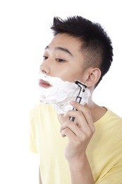 	portrait of young man shaving	