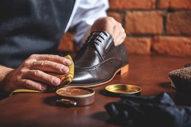 man shining shoes with a rag