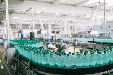 industrial factory indoors and machinery. robotic factory line for processing and bottling of pure spring water into canisters and bottles. selective focus. short depth of field.