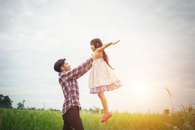 daddy carrying his daughter with nature and sunlight, enjoyment family.