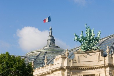 the grandeur of paris in the facade of a richly ornamented building on the champs elisee; the grand palace basking in the morning sun
