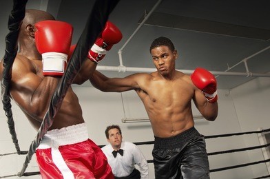 boxers fighting in ring with referee watching