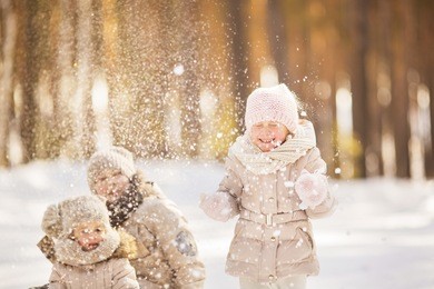 portrait of two little girls play with snow in winter