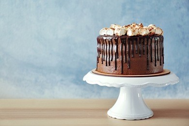 chocolate cake with marshmallow on plastic stand on wall background