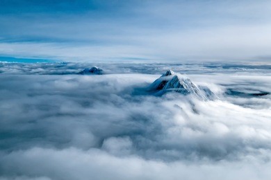 panorama of the himalaya mountains rising from the clouds