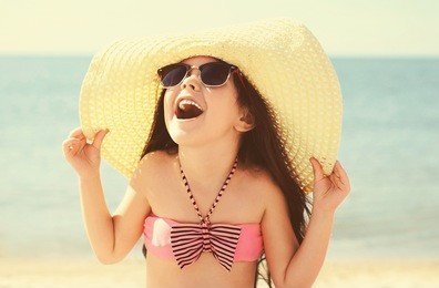 little girl in sunglasses relaxing on beach