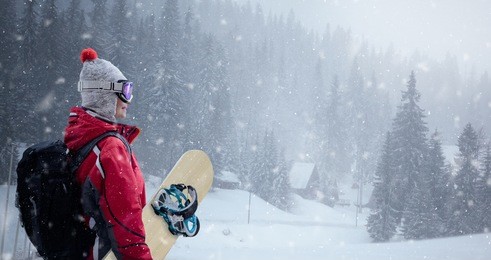 woman in ski suit over winter background, snowboarding, winter sport 