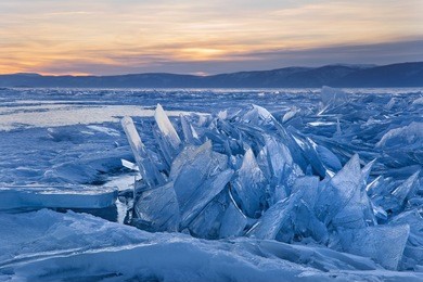 lake baikal in siberia at sunset, a pile of beautiful ice hummocks with reflection. the natural background.