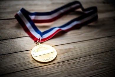 award of victory. winners at the best games, gold medal on a wooden table