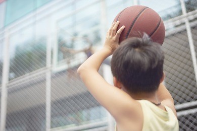 asian boy preparing for basketball shooting at playground