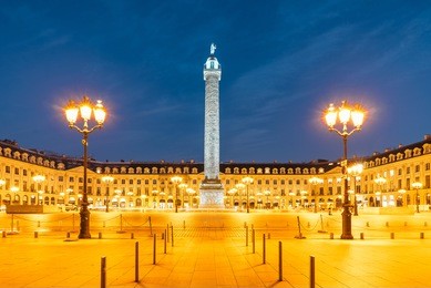 vendome column with statue of napoleon bonaparte, on the place vendome at night, in france. vendome column has 425 spiraling bas-relief bronze plates were made out of cannon.