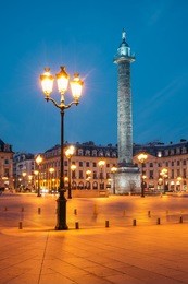 vendome column with statue of napoleon bonaparte, on the place vendome at night, in france. vendome column has 425 spiraling bas-relief bronze plates were made out of cannon.