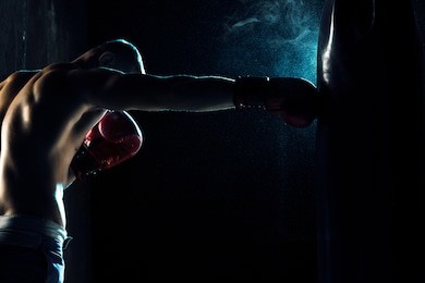 male boxer boxing in punching bag