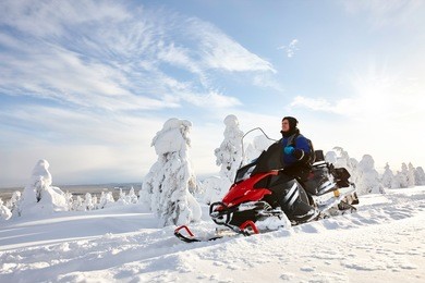 man driving snowmobile in finland