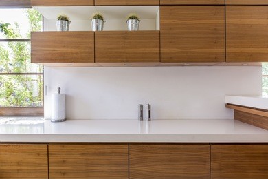 wooden kitchen units and white worktop in modern interior