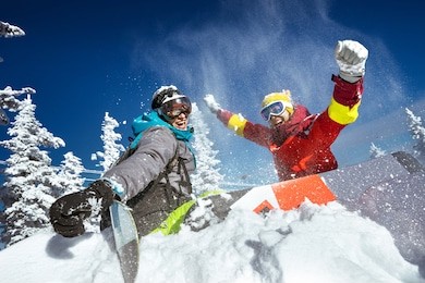 happy couple of snowboarders having fun tossing snow and smiling
