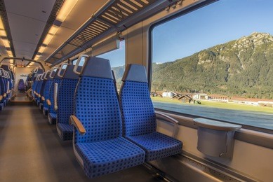 train chairs and view through window - comfortable chairs on a modern german train, with beautiful alpine view through the window