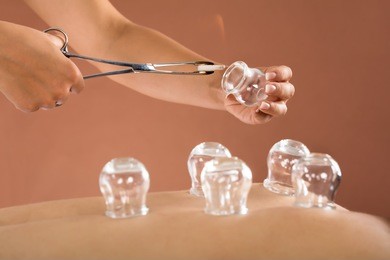 close-up of a therapist giving cupping therapy to man in spa