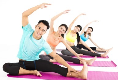 smiling young fit group stretching in gym