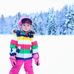 happy child enjoying vacation in alpine resort. little girl skiing in mountains. active sportive toddler wearing helmet and glasses learning to ski. winter sport for family. skier racing in snow.