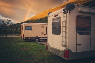 camping under the rainbow. two compact motorhomes wild camping in norway. camper traveling.