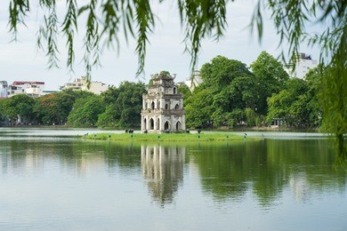 hoan kiem lake (sword lake, ho guom) in hanoi, vietnam with willow branches on foreground