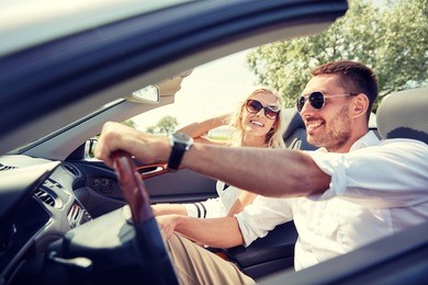 road trip, travel, dating, couple and people concept - happy man and woman driving in cabriolet car outdoors