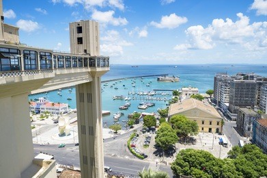 scenic city skyline view of salvador, brazil with lacerda elevator, bay of all saints, and old lower city architecture on the horizon