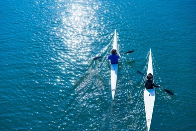 water sports image, people rowing in canoe on river