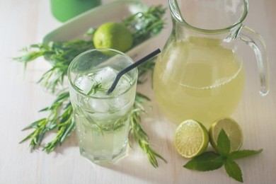 homemade lemonade from lime and tarragon on white wooden background