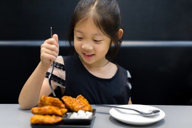 child eating fried chicken