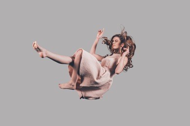 falling to somewhere. studio shot of attractive young woman hovering in air